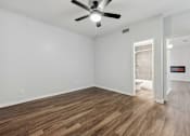 Thumbnail 8 of 79 - an empty living room with a ceiling fan and a bathroom