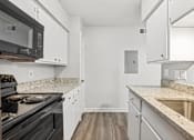 Thumbnail 12 of 79 - a renovated kitchen with white cabinets and granite counter tops and black appliances
