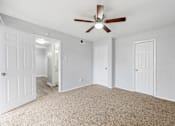 Thumbnail 15 of 79 - an empty bedroom with a ceiling fan and white doors