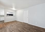 Thumbnail 13 of 79 - the living room and kitchen of an apartment with wood flooring and white walls