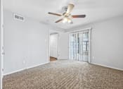 Thumbnail 26 of 79 - an empty living room with a ceiling fan and a door to a balcony