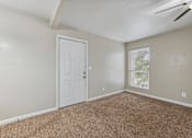 Thumbnail 25 of 79 - an empty living room with a white door and a window