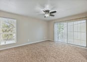 Thumbnail 32 of 79 - an empty living room with a ceiling fan and a window