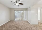 Thumbnail 28 of 79 - an empty living room with a ceiling fan and a window