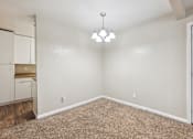 Thumbnail 33 of 79 - the spacious living room with white walls and carpet and a door to the kitchen