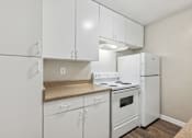 Thumbnail 31 of 79 - a white kitchen with white appliances and white cabinets