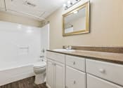 Thumbnail 36 of 79 - a bathroom with a toilet and a sink and a mirror