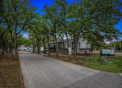 Thumbnail 19 of 79 - a street with a building and trees on both sides of it