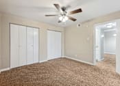 Thumbnail 35 of 79 - an empty living room with carpet and a ceiling fan