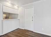 Thumbnail 64 of 79 - a living room with white walls and a door to a kitchen