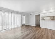 Thumbnail 37 of 79 - the living room and kitchen of an apartment with white walls and wood floors