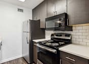 Thumbnail 1 of 79 - a kitchen with a stove microwave and refrigerator