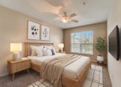 Thumbnail 6 of 42 - a bedroom with a large bed and a ceiling fan