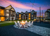 Thumbnail 23 of 28 - a patio with a fire pit and chairs at the enclave at woodbridge apartments in sugar land