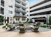 Thumbnail 14 of 31 - courtyard with fire pit and seating area at the district flats apartments