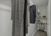 Thumbnail 11 of 28 - a small room with a wardrobe and a radiator and clothes hanging on the wall