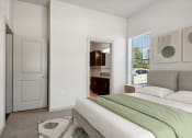 Thumbnail 6 of 28 - a bedroom with a bed and a door to a bathroom