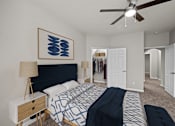 Thumbnail 6 of 52 - A bedroom with a bed, a ceiling fan, and a painting on the wall.