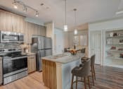 Thumbnail 4 of 52 - a kitchen with stainless steel appliances and a island with chairs