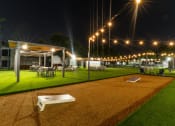 Thumbnail 39 of 41 - a night view of a yard with tables and chairs and lights