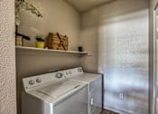 Thumbnail 9 of 22 - A small kitchen with a stove top oven and a wall-mounted shelf with a plant and a basket on it.