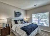 Thumbnail 4 of 22 - A bedroom with a large bed and a window with blinds.