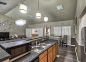 Thumbnail 13 of 22 - A kitchen with a black microwave, stainless steel refrigerator, and wooden cabinets.