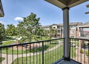 Thumbnail 10 of 22 - A balcony overlooks a playground and apartment buildings.