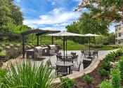 Thumbnail 25 of 35 - a patio with tables and umbrellas and barbecue grills