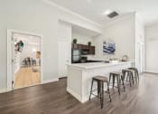 Thumbnail 24 of 53 - a kitchen with a white counter top and bar stools