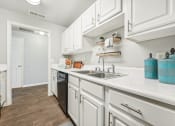 Thumbnail 6 of 53 - a kitchen with white cabinets and a sink    and a door to a