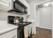 Thumbnail 5 of 53 - the kitchen of a home with a stove and a microwave