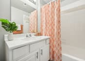 Thumbnail 13 of 53 - a bathroom with a sink and a tub and a shower curtain