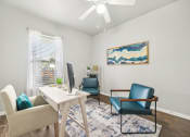 Thumbnail 9 of 53 - a living room with chairs and a table and a ceiling fan