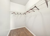 Thumbnail 16 of 53 - a room with white walls and wood flooring and a closet with clothes hangers