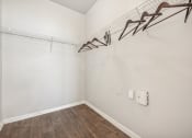 Thumbnail 17 of 53 - an empty room with white walls and wood flooring and a white closet with hooks