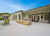Thumbnail 36 of 53 - a patio with a fire pit and chairs and a house