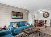 Thumbnail 1 of 18 - a living room with a blue couch and a coffee table