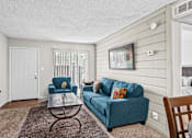 Thumbnail 2 of 18 - a living room with a blue couch and a coffee table