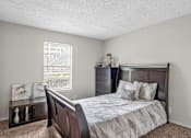 Thumbnail 8 of 18 - a bedroom with a bed and a dresser