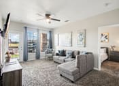 Thumbnail 2 of 36 - a living room with a couch and a chair and a ceiling fan