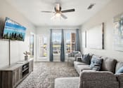 Thumbnail 1 of 36 - a living room with a couch and a ceiling fan