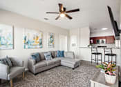 Thumbnail 3 of 36 - a living room with a couch and a chair and a ceiling fan