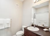 Thumbnail 11 of 36 - a bathroom with a sink and a toilet and a mirror