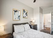 Thumbnail 9 of 36 - a bedroom with a white bed and two paintings on the wall