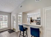 Thumbnail 14 of 21 - the preserve at ballantyne commons apartment kitchen and bar with blue chairs