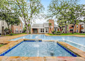 Thumbnail 16 of 21 - a swimming pool with a fountain in front of an apartment building