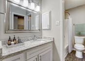 Thumbnail 7 of 21 - a bathroom with a toilet and a sink and a mirror