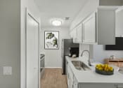 Thumbnail 4 of 28 - an open kitchen and living room with white cabinets and a white counter top