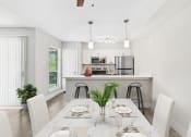 Thumbnail 13 of 41 - a dining area with a table and chairs and a kitchen in the background